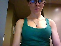 Geeky brunette displays her delicious cleavage in a green t